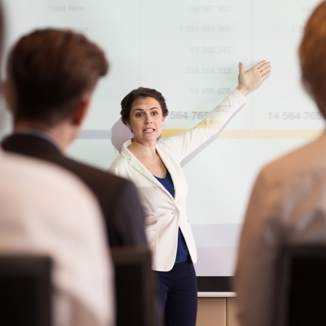 serious-businesswoman-showing-table-audience
